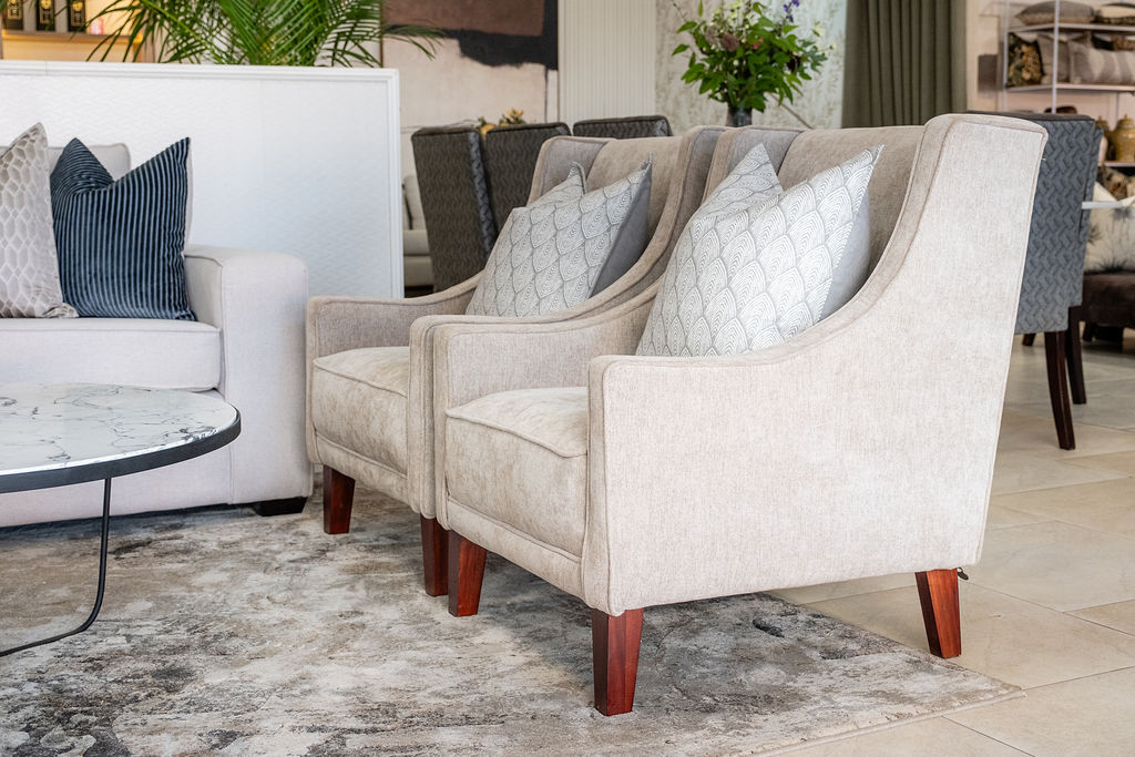 Beige wingback armchairs with marble coffee table in a bright showroom