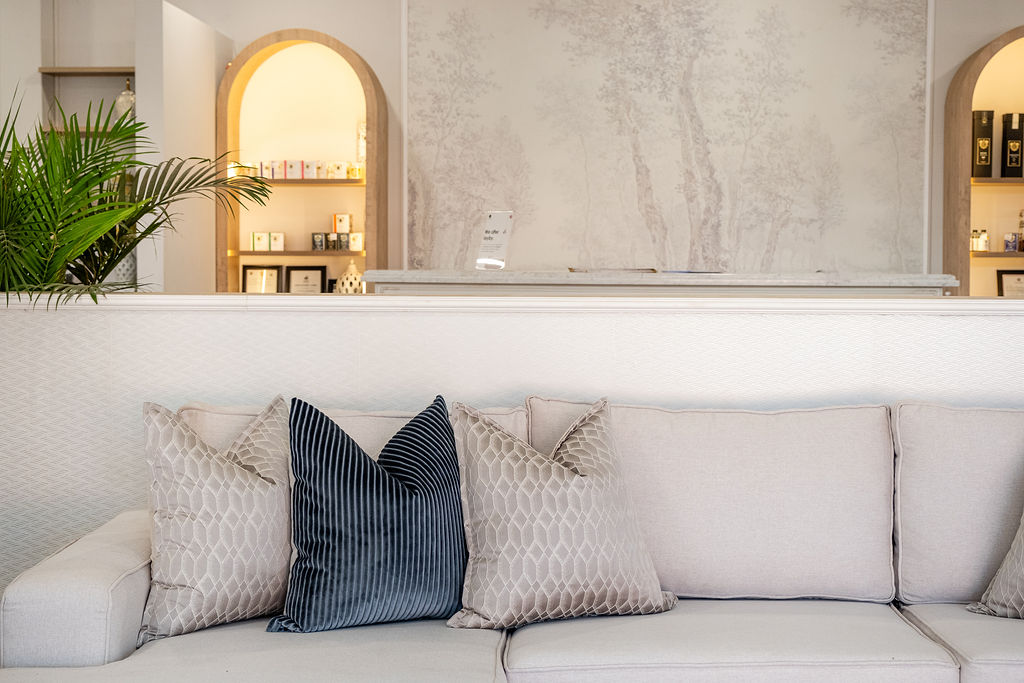 Light sofa with quilted and navy corduroy cushions against arched display niches