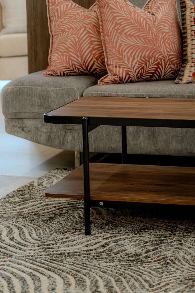 Two-tier wood and metal coffee table with terracotta palm-print sofa cushions